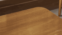 a person 's hands on a wooden table with their fingers crossed