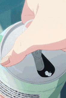 a person is opening a soda can with the letter o on the lid