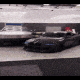 a gray car is parked next to a white car in a parking garage