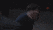 a man is being held by a woman in a dark room .