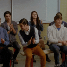 a group of people sitting on a bench with one man giving the thumbs up
