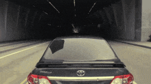 a toyota corolla is driving through a dark tunnel