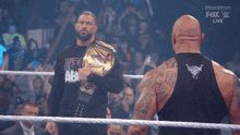 two wrestlers are standing in a ring and one is wearing a shirt that says new age
