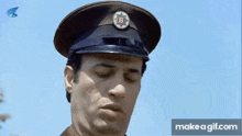 a man in a military uniform is wearing a hat with a letter b on it .