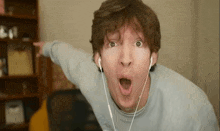 a man wearing headphones is making a funny face while making a funny face .
