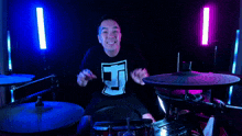 a man wearing a shirt that says e on it playing drums