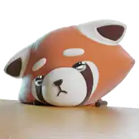 a stuffed animal that looks like a red panda is laying on a wooden table
