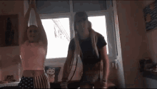 a man and a woman are dancing in front of a window .