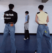 three men are standing in front of a white wall and their backs are shown with the words tiktok @enhypen on the bottom