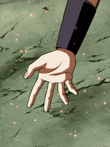 a person 's hand is reaching out towards the ground