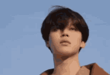 a close up of a young man looking up at the sky .
