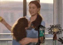 a woman is hugging another woman with a drawing of a woman in the background