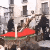 a group of people are standing around a statue of jesus on a cross in front of a crowd .
