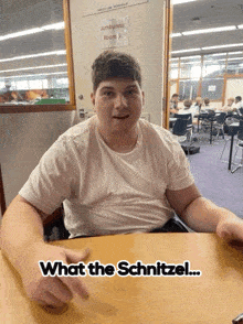 a man sitting at a table with the words what the schnitzel on the bottom