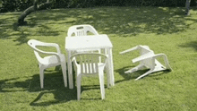 a table and chairs are sitting on a lush green field .