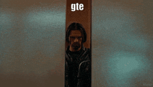 a group of people standing in an elevator with the word gte on the wall