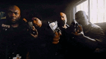 a group of men holding guns with one wearing a shirt that says offo