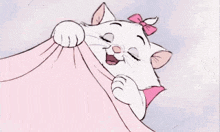 a white cat with a pink bow on its head is laying on a pink blanket .