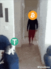 a man in a black shirt and red shorts is standing in a hallway with a circle with the letter b on it