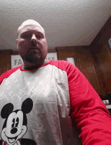 a bald man with a beard is wearing a mickey mouse sweater .