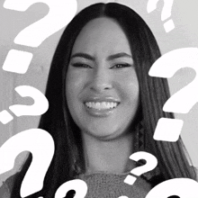 a woman is smiling with question marks around her head