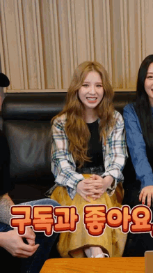 a woman in a plaid shirt is smiling while sitting on a couch with two other women