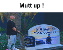 a man is standing in front of a gravestone that says " in memory of max cooper "