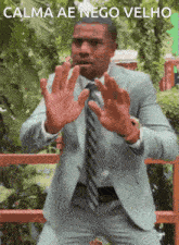 a man in a suit and tie is making a stop gesture