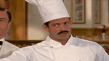 a man wearing a chef 's hat and a mustache