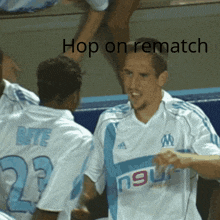 a soccer player wearing a number 23 jersey talks to another player