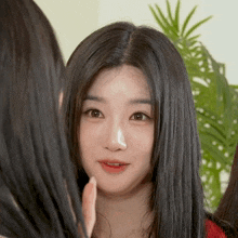 a woman with long black hair looks at another woman