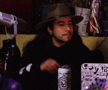 a man wearing a hat is holding a can of beer that says club jaguares on it