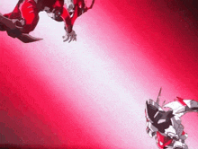 a couple of robots are fighting each other in a red light .