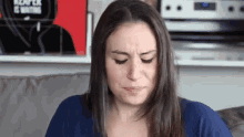 a woman is sitting on a couch with her eyes closed and a book behind her that says black is nothing