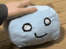 a blue stuffed animal with a face on it