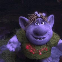 a troll wearing a green sweater and red beads