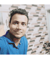 a man in a blue shirt smiles for the camera