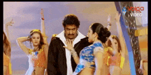 a man and a woman are dancing in front of a video screen that says video