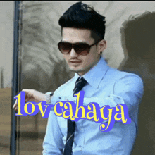 a man wearing sunglasses stands in front of a sign that says lov cahaya on it