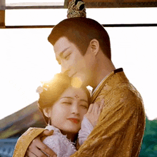 a man in a gold costume is hugging a woman