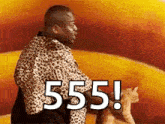 a man in a leopard print shirt is holding a cat and saying 555 !