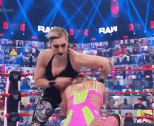 two women are wrestling in a ring with the words raw on the screen behind them