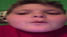 a close up of a boy 's face with a green background