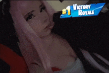 a woman with pink hair is laying on a bed with a sign that says victory royale on it .