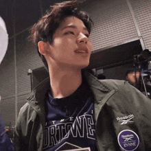 a young man wearing a reebok jacket and shirt