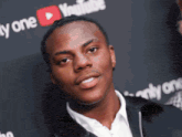 a man is standing in front of a youtube sign