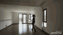 a woman is walking through an empty room with a sign that says master bedroom