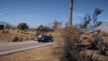 a car is driving down a road with mountains in the background