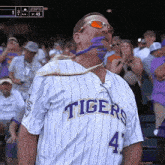 a man wearing a tigers jersey and sunglasses