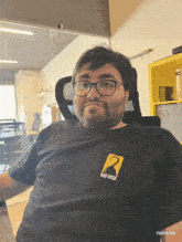 a man wearing glasses and a black shirt that says mad hook on it